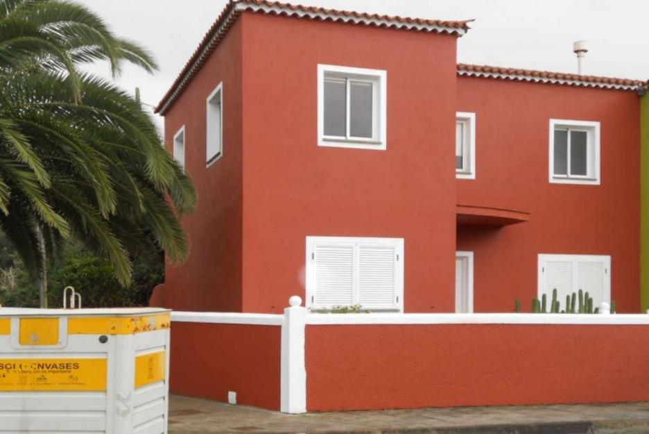 preciosa casa el drago de color granate y blanco con vistas a la montaña